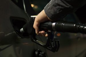 Does the Brand of Gas I Use in my Car Actually Matter? Hand pumping gasoline into car