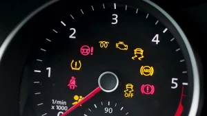 Many different car dashboard lights with warning lights illuminated.