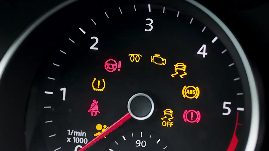 Many different car dashboard lights with warning lights illuminated.
